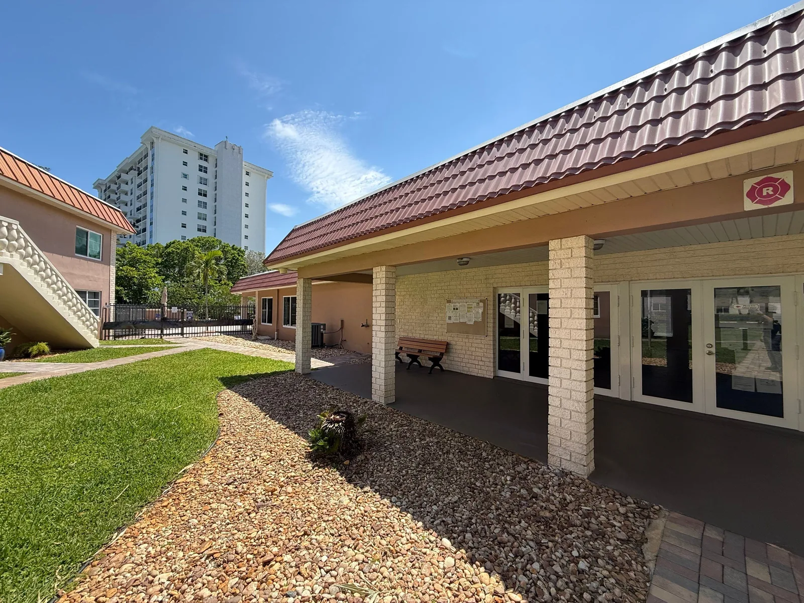 Commercial Painting in Fort Lauderdale, Florida. Single-storey community building with painted tan block walls, covered entry walkway and tile roof.