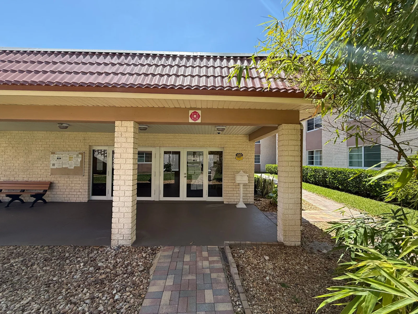 Commercial Painting in Fort Lauderdale, Florida. Front elevation of a single-storey community building with painted block columns and glass entry doors.
