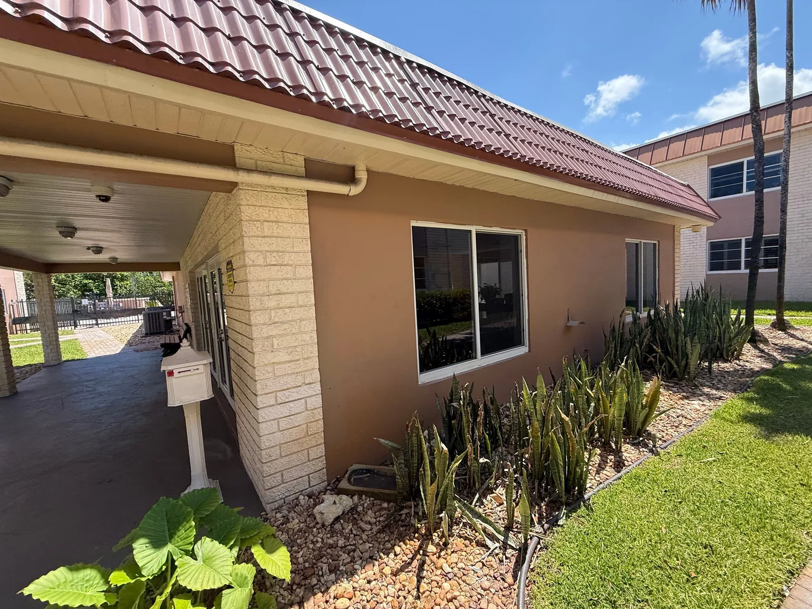 Commercial Painting in Fort Lauderdale, Florida. Side elevation of a building with painted tan stucco, white window trim and block corner detail.