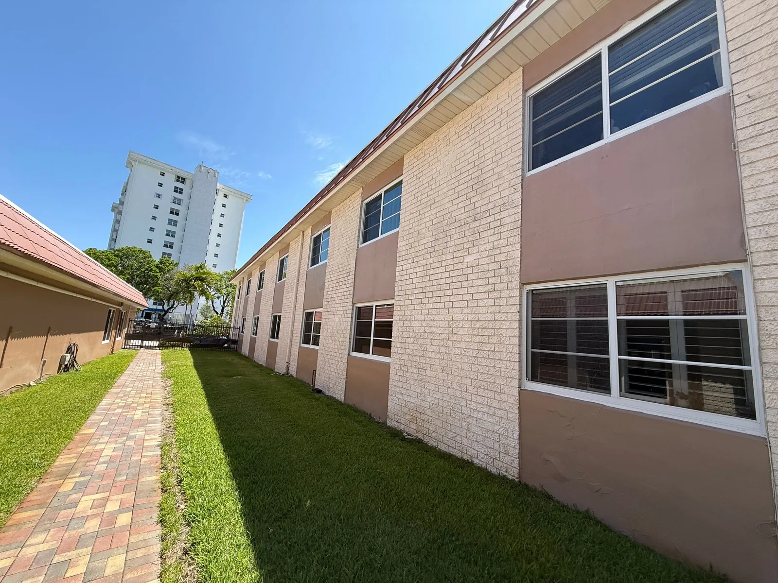 Commercial Painting in Fort Lauderdale, Florida. Two-storey apartment building side elevation with painted block and two-tone stucco panels.