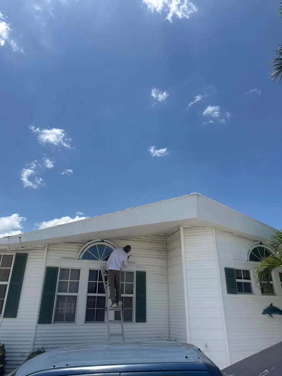 Painter working on the front exterior of a home on Nettles Island