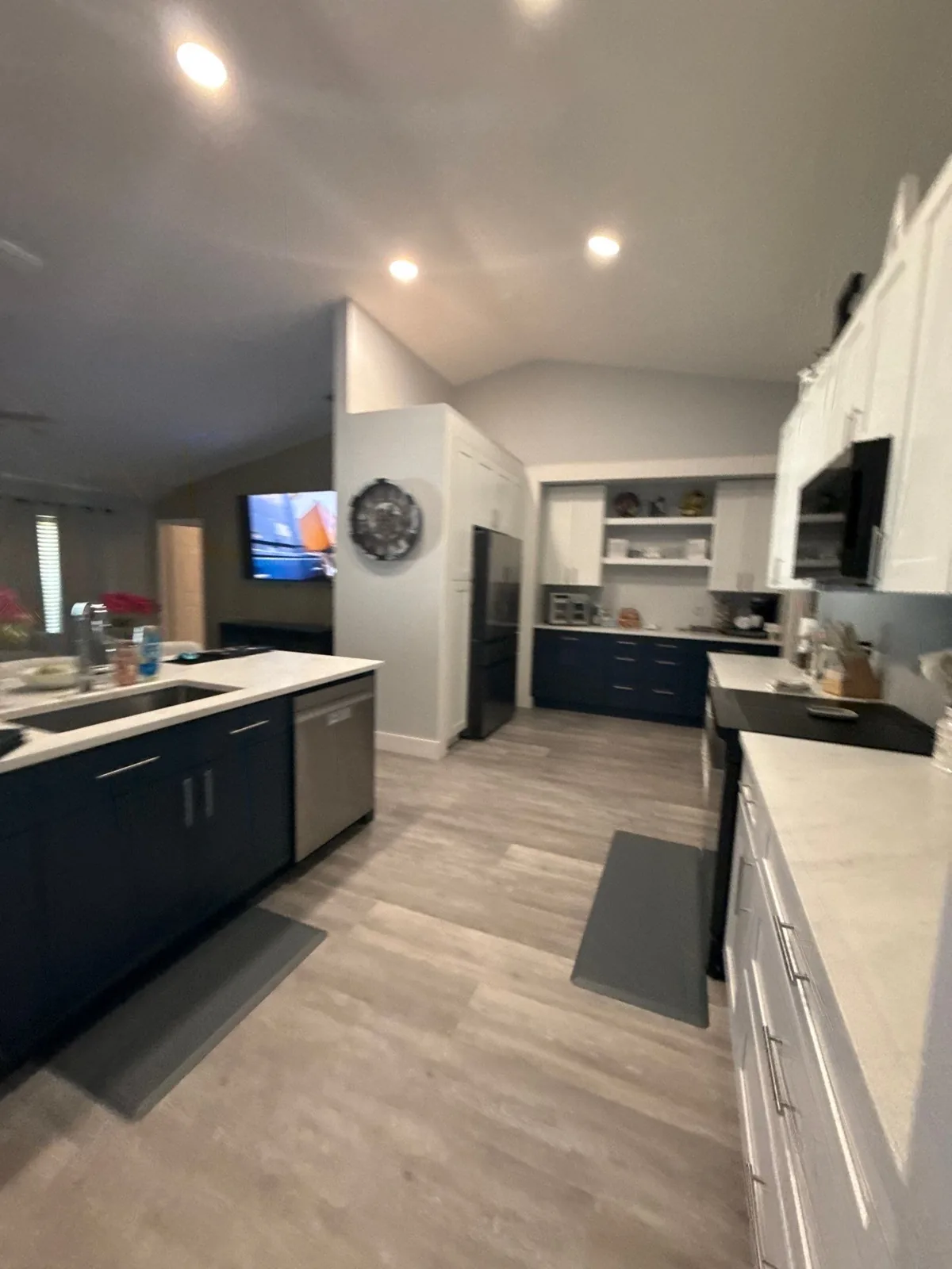 Cabinet Refinishing in Port Saint Lucie, Florida. Kitchen with navy blue lower cabinets, white upper cabinets and a vaulted white ceiling.