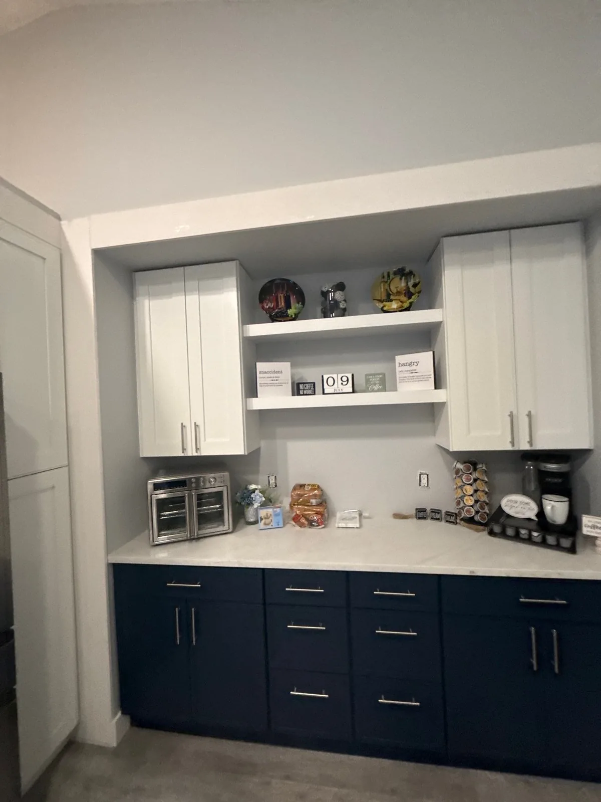 Cabinet Refinishing in Port Saint Lucie, Florida. Built-in coffee bar with navy blue lower cabinets, white upper cabinets and a white open shelf.