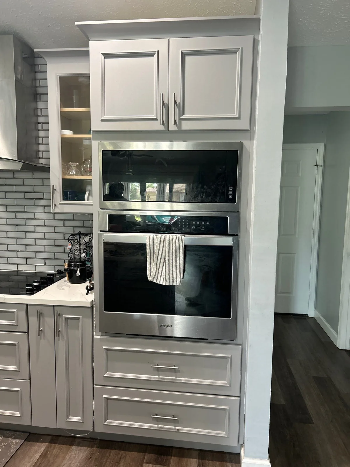 Cabinet Refinishing in Port Saint Lucie, Florida. Light grey refinished cabinets around a stainless double wall oven, white subway tile backsplash.