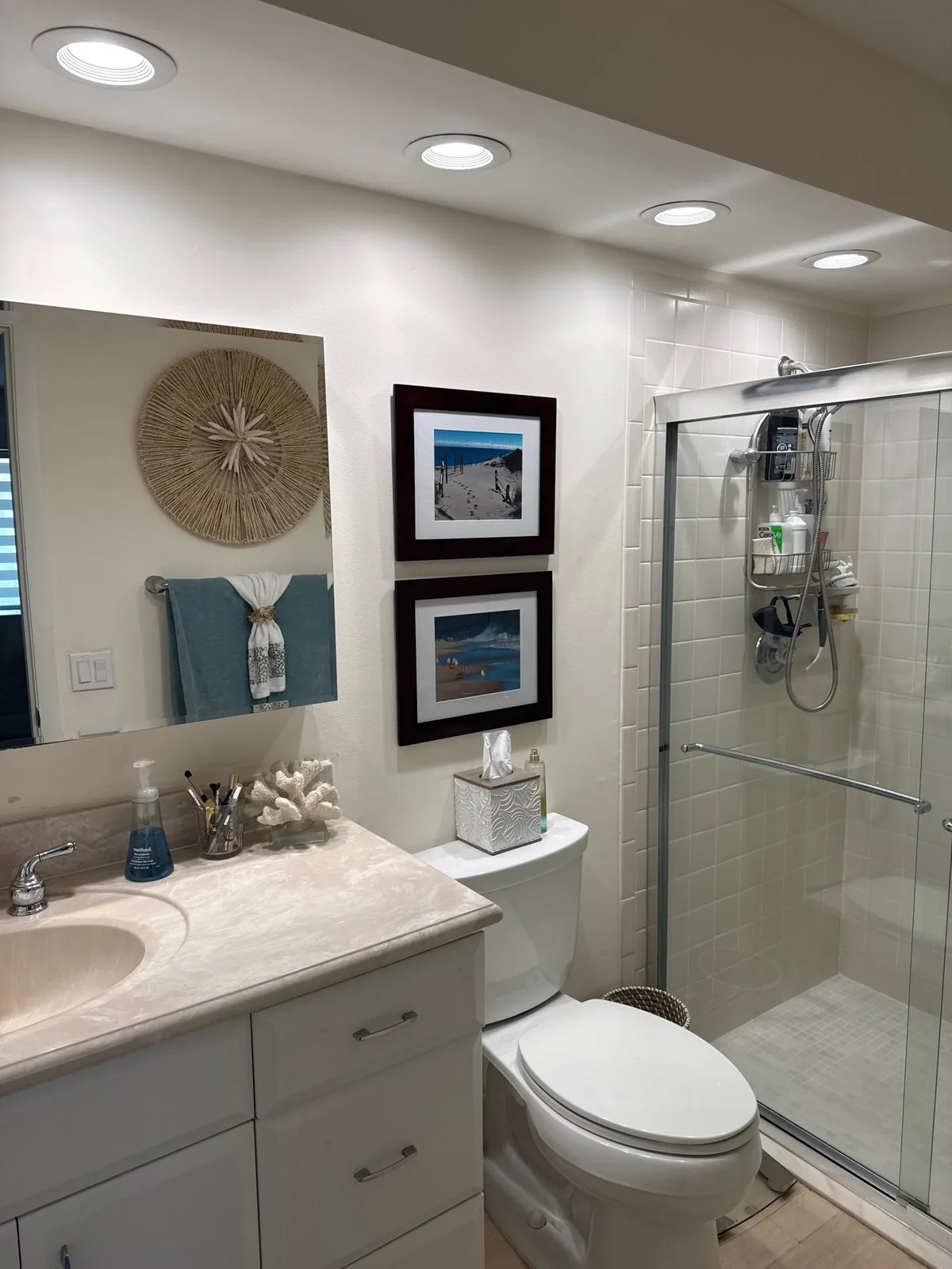 Interior Painting in Royal Palm Beach, Florida. Finished bathroom with white walls and ceiling, recessed lighting, vanity and glass shower enclosure.