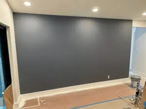 High-ceiling residential interior with a charcoal gray accent wall and white trim expertly finished