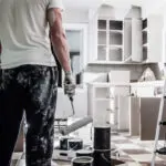 Painter refinishing kitchen cabinets in a Fort Lauderdale home
