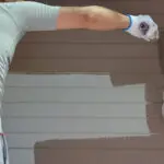 Painter applying exterior paint to a home in Port St. Lucie