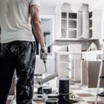 Painter refinishing kitchen cabinets in a Fort Lauderdale home