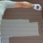 Painter applying exterior paint to a home in Port St. Lucie