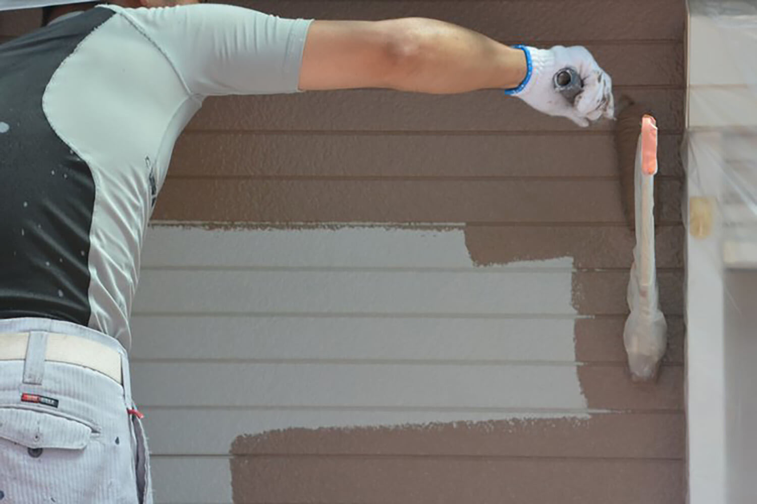 Painter applying exterior paint to a home in Port St. Lucie