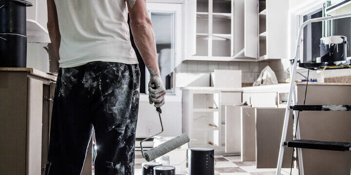 Painter refinishing kitchen cabinets in a Fort Lauderdale home