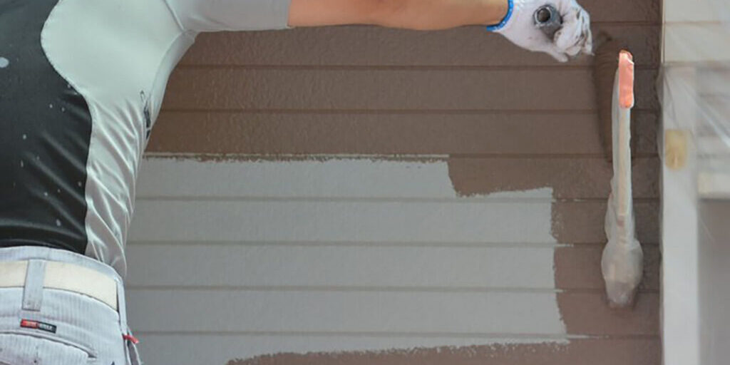 Painter applying exterior paint to a home in Port St. Lucie